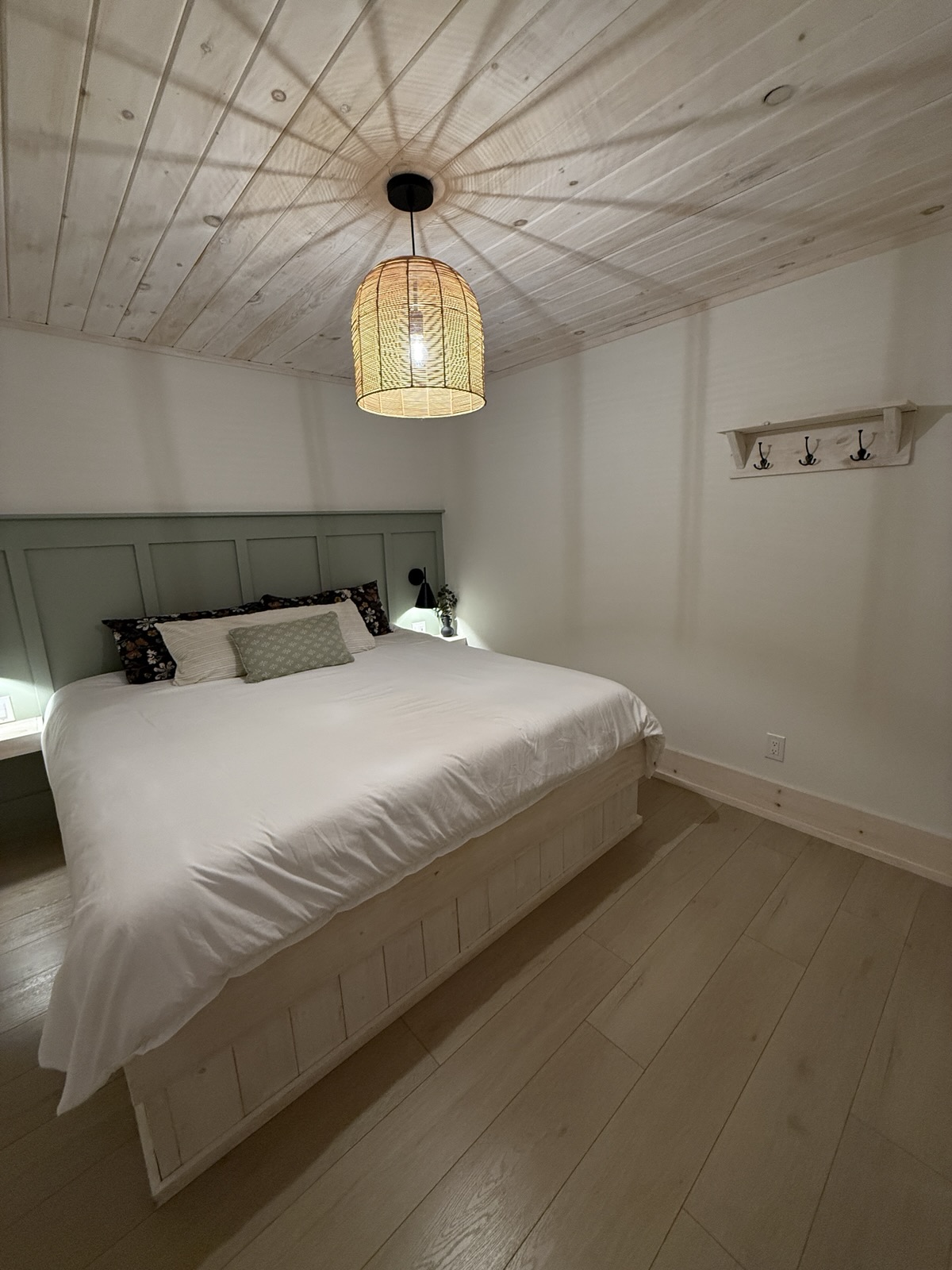 The king room with its rattan pendant and sage headboard