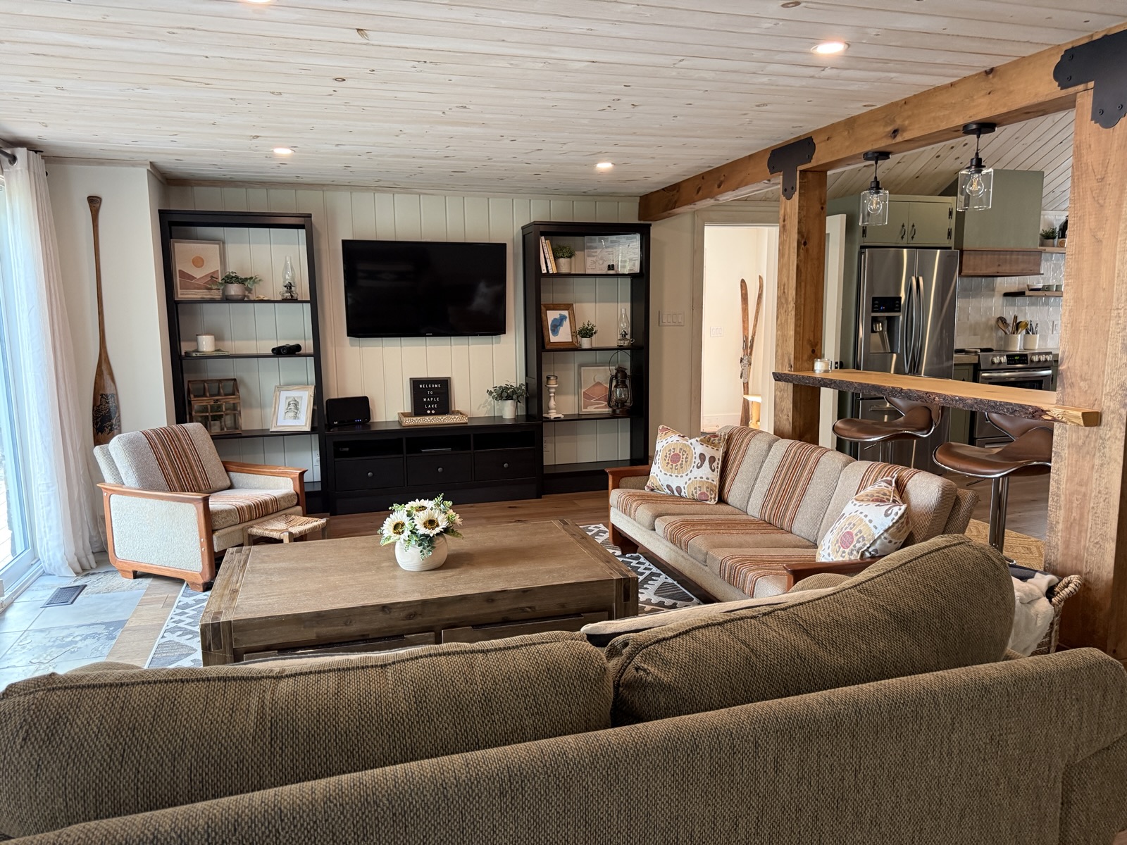 The living room with the sectional, built-ins, and timber beam