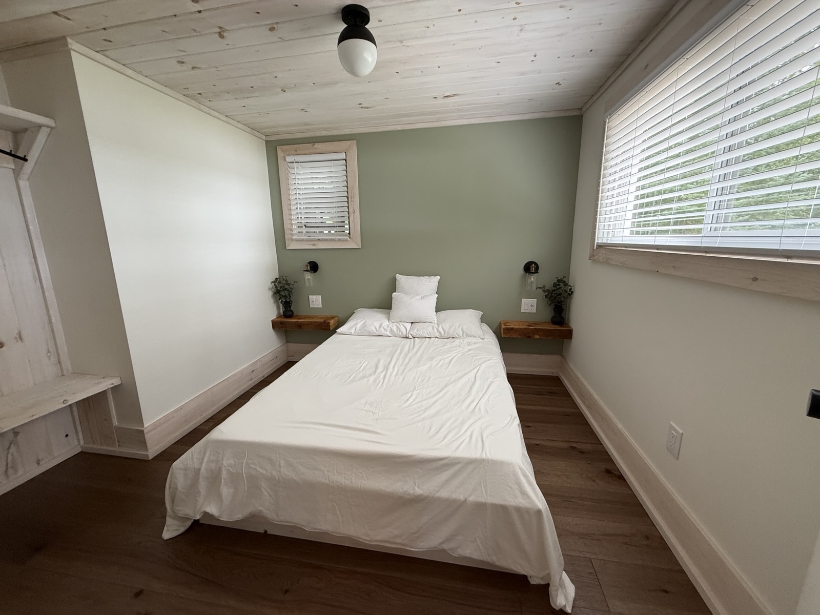 The double room with sage walls and two windows